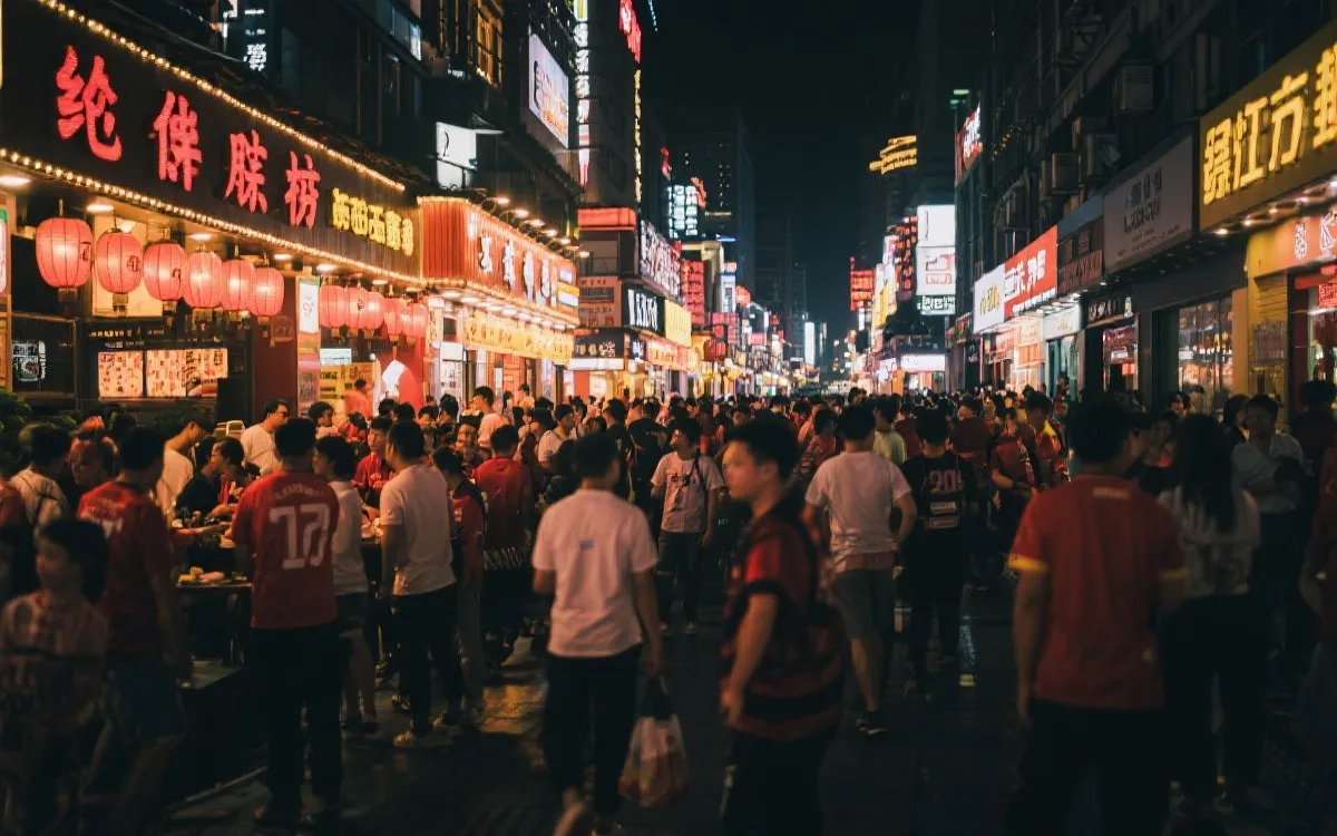 城市夜间商圈与球迷聚集的街头场景，灯光与人流形成消费热区